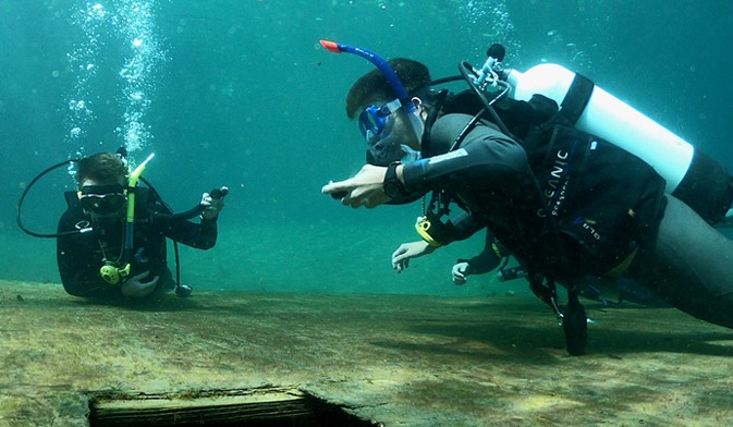 Two students in SCUBA gear underwater